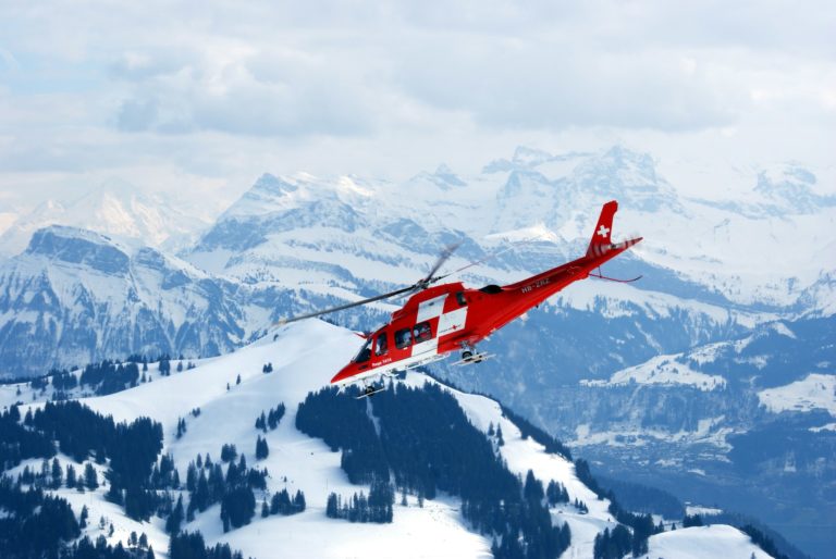 Elicottero rosso del soccorso alpino su montagna innevata