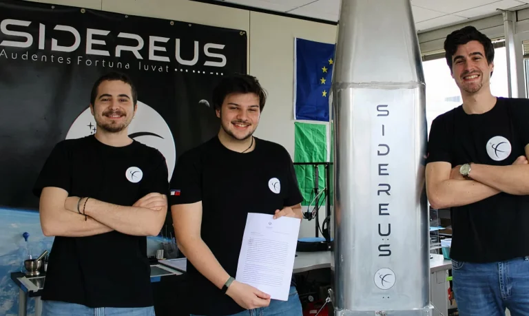 tre ragazzi giovanissimi fondatori della startup Sidereus con il modulo spaziale EOS da loro creato, che ha la forma di un cono alto circa 2 mt