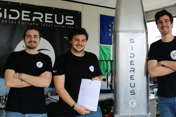 tre ragazzi giovanissimi fondatori della startup Sidereus con il modulo spaziale EOS da loro creato, che ha la forma di un cono alto circa 2 mt